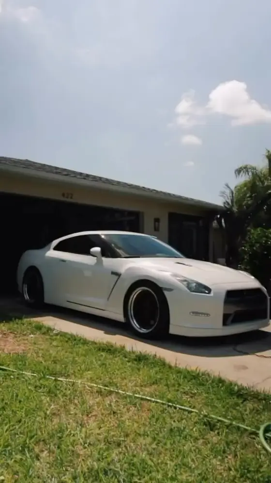 White Nissan GT-R parked in a driveway after a wash