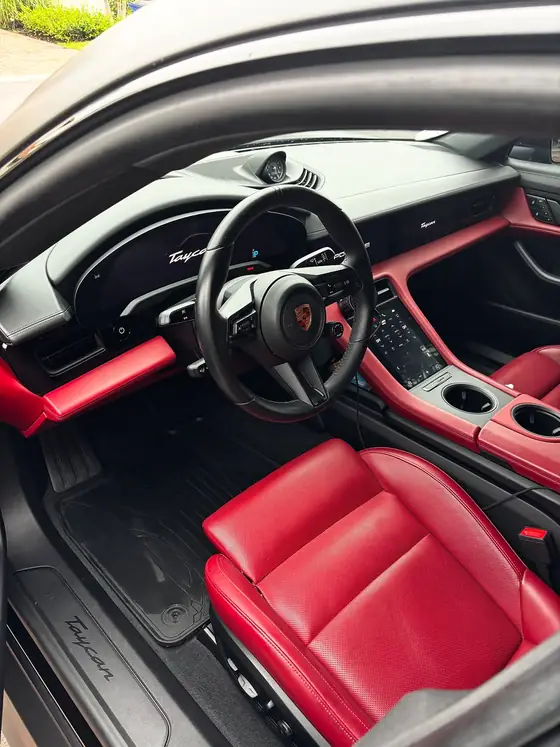 Porsche Taycan cockpit with red leather seats and clean floor mats