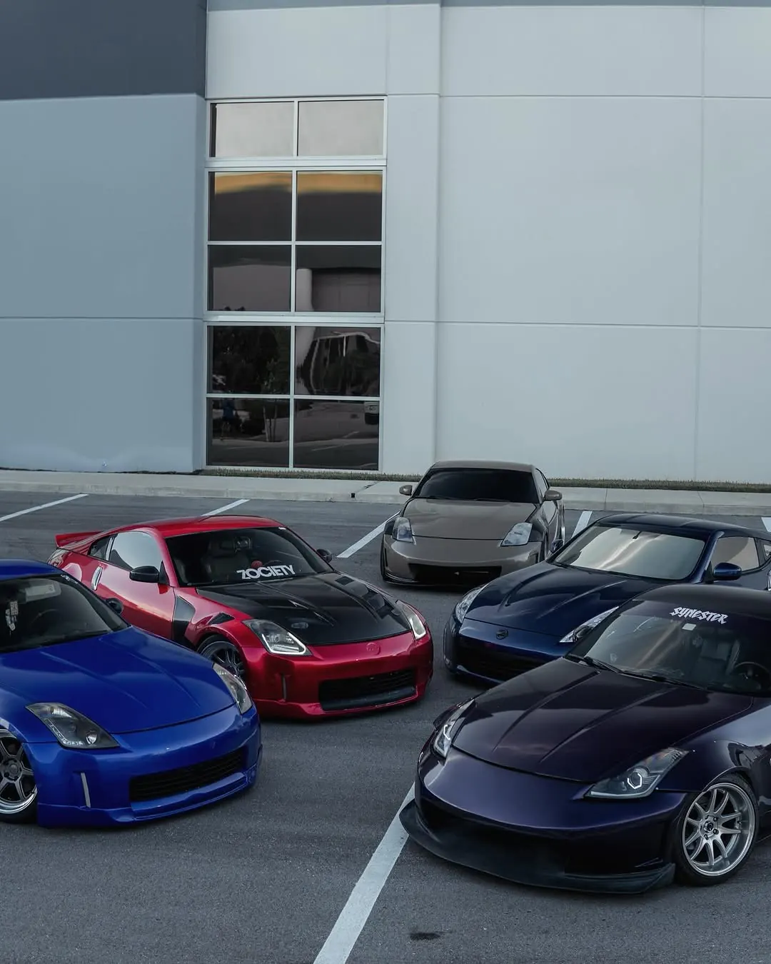 A lineup of six Nissan Z cars parked together at a meet